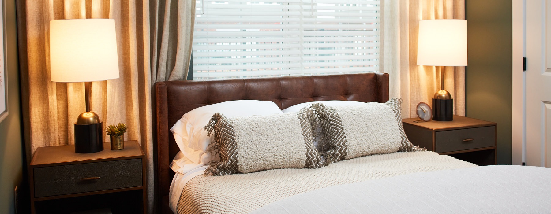 Bedroom with large bed, ensuite. queen bed and nightstands.